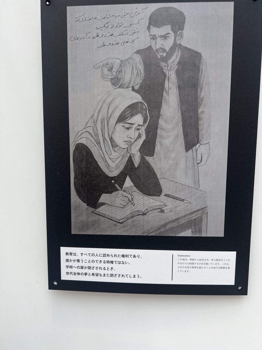 ノートに向かう少女と、指をさす男性を描いた鉛筆画