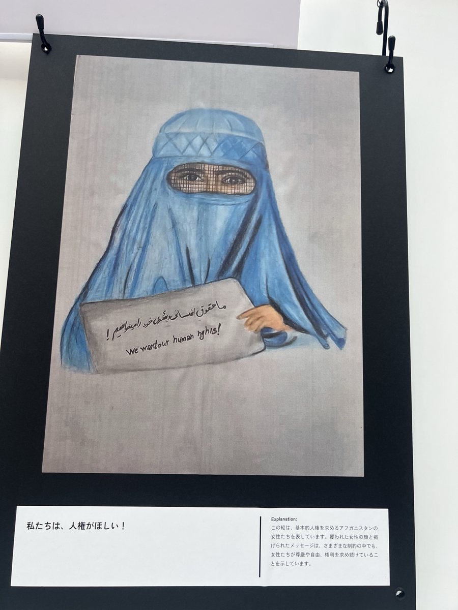 青いブルカの女性が人権を求めるメッセージを掲げる絵