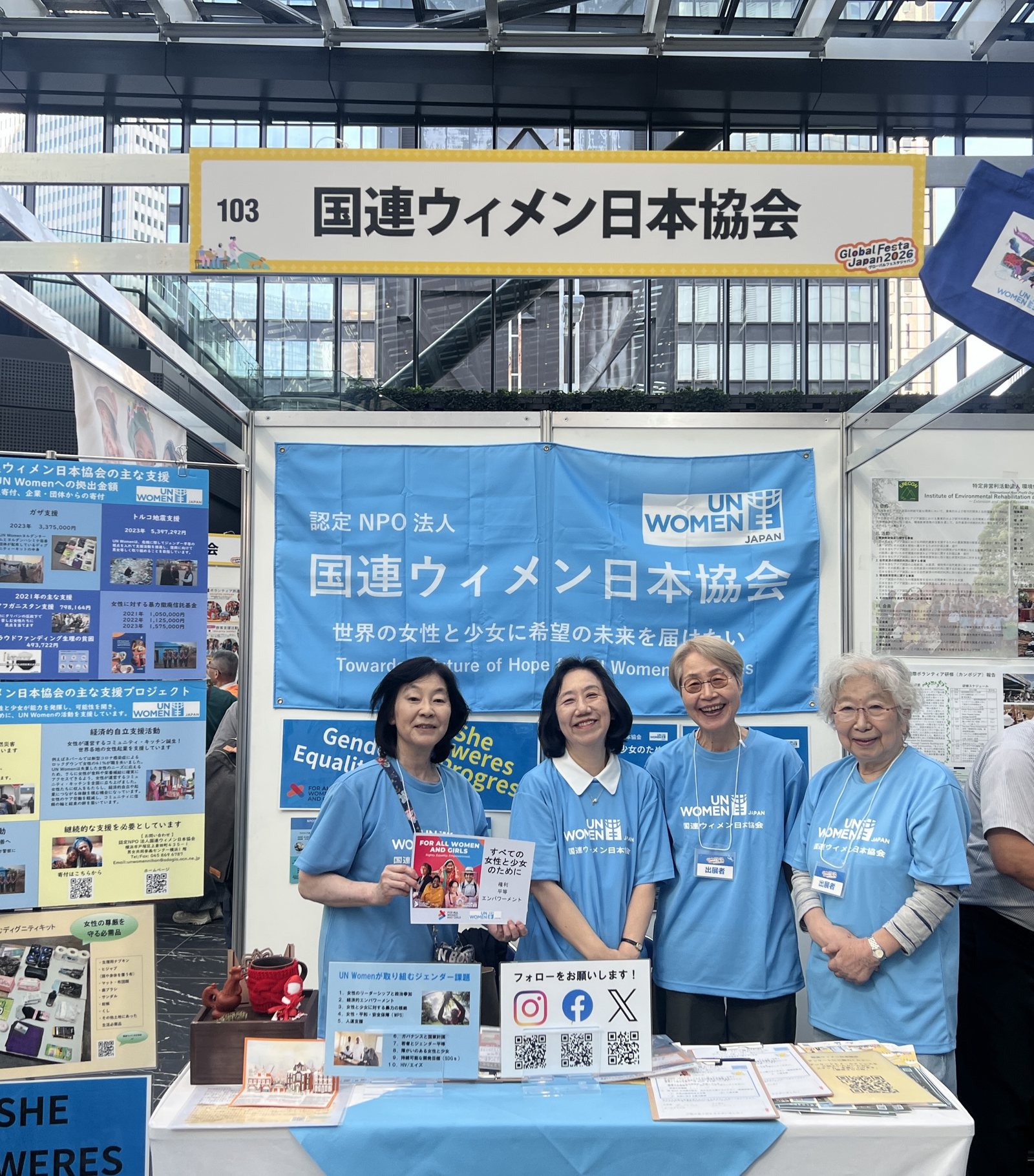 グローバルフェスタJAPAN 2026の国連ウィメン日本協会のブース。水色のTシャツのスタッフ4人が並ぶ